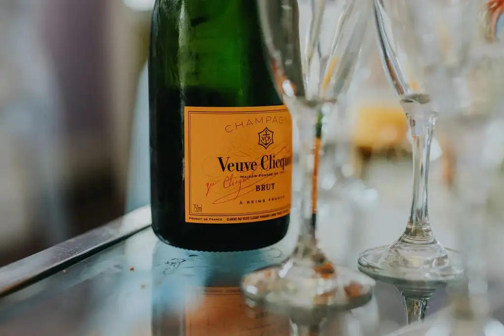 Close-up of a Veuve Clicquot champagne bottle beside elegant champagne flutes on a reflective surface, creating a celebratory atmosphere at Rowton Castle.
