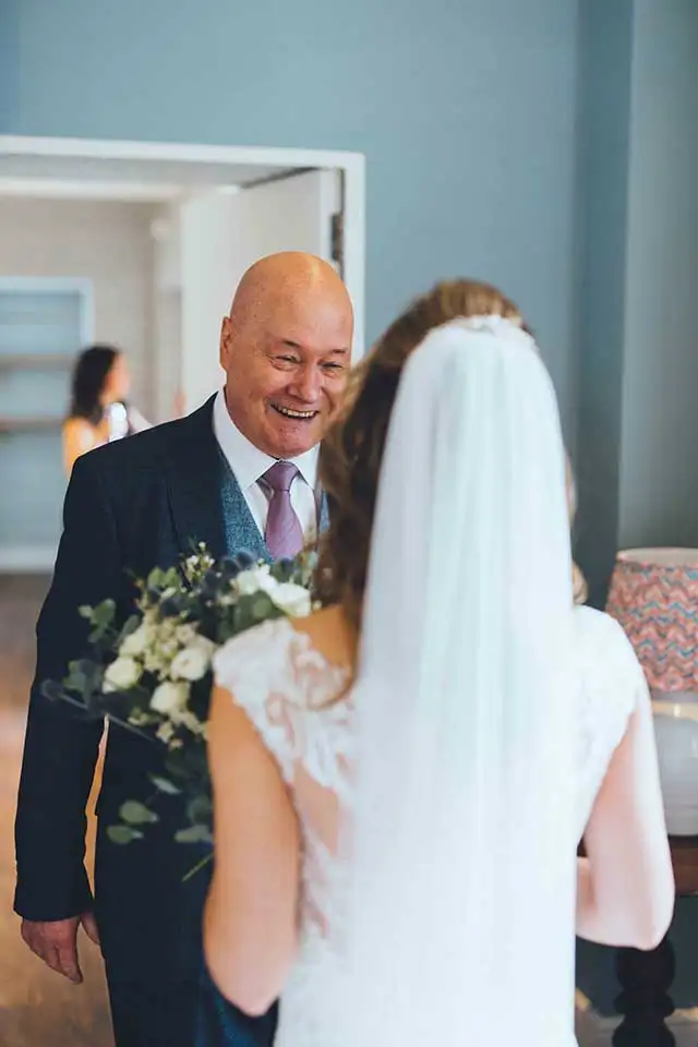 Father smiling as he sees the bride for the first time