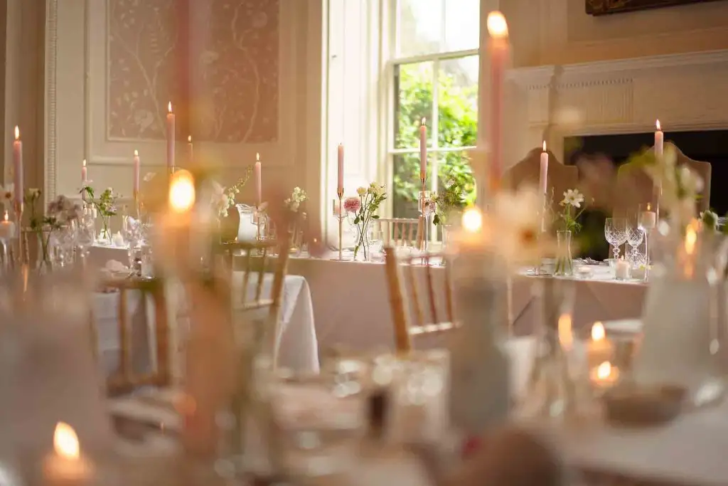 Candlelit wedding reception tables with floral arrangements in the Rowton Castle dining room