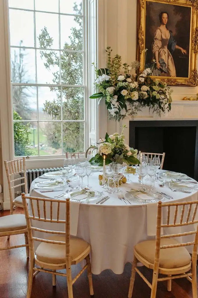 Floral wedding table centrepiece with candles and glassware at Rowton Castle