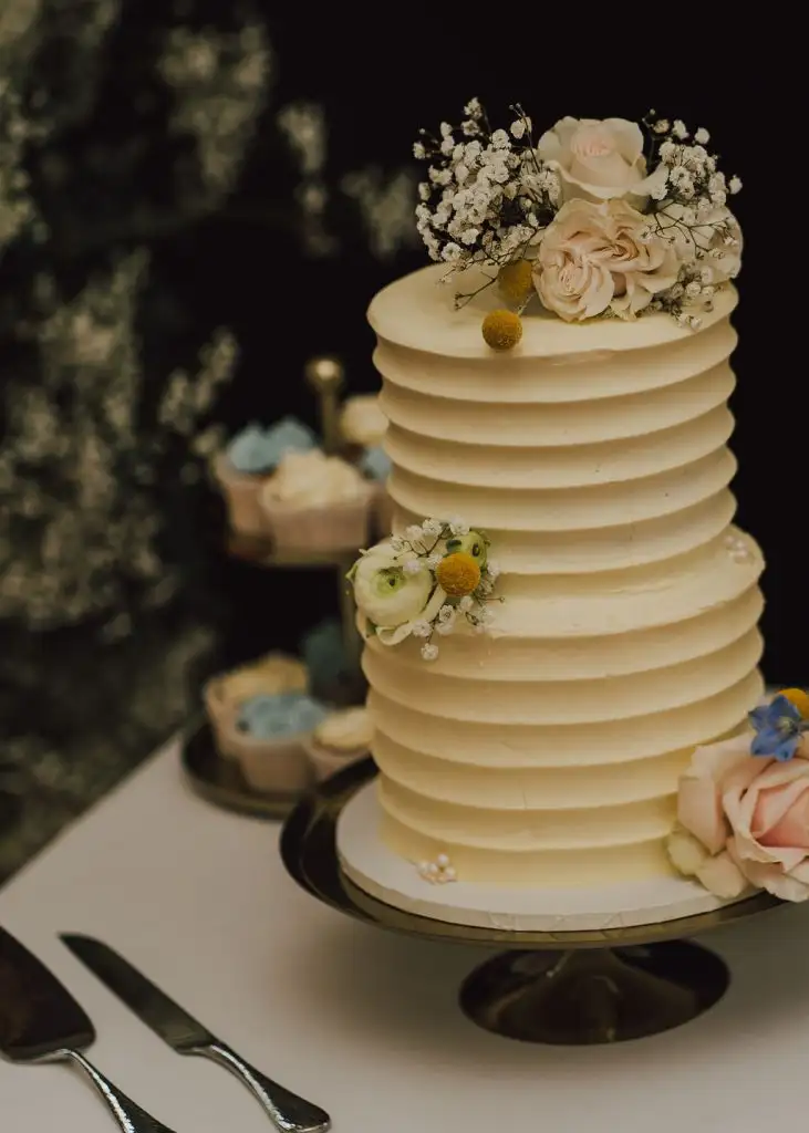Elegant tiered wedding cake decorated with flowers at Rowton Castle reception