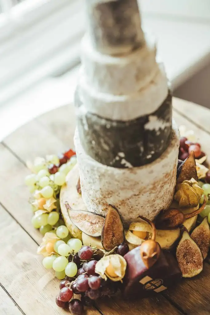 Rustic tiered cheese wedding cake with grapes, figs and fruit at Rowton Castle reception