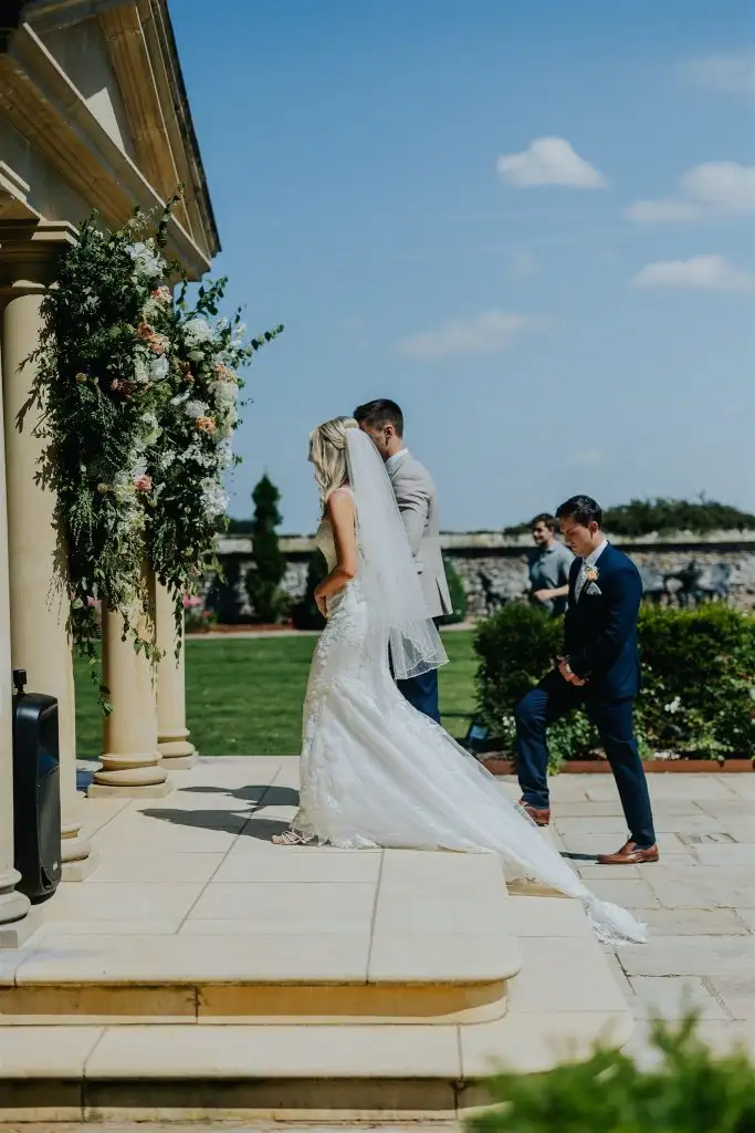 Bride and groom standing at the temple during their outdoor wedding ceremony at Rowton Castle