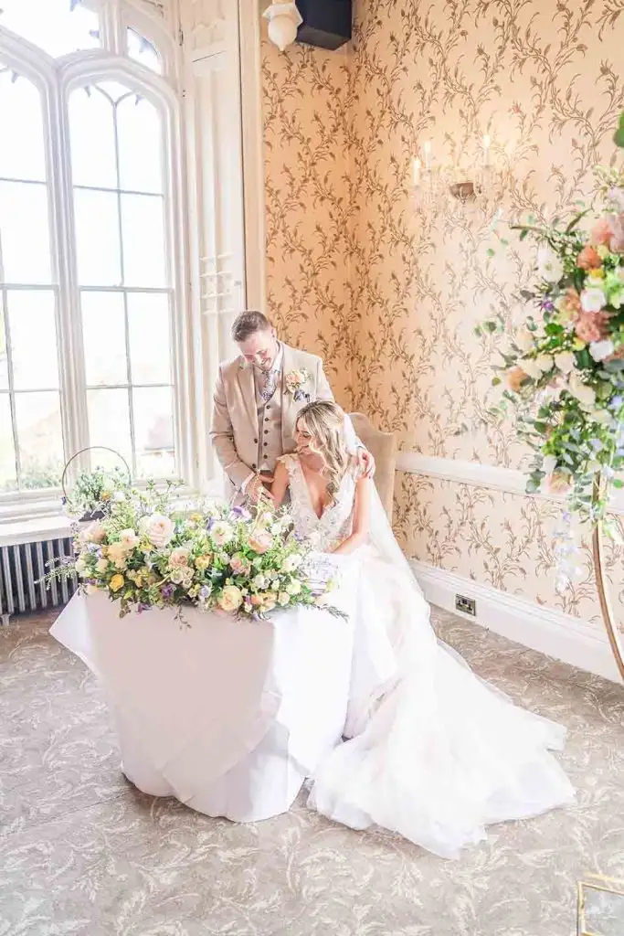 Bride and groom signing the wedding register inside Rowton Castle ceremony room
