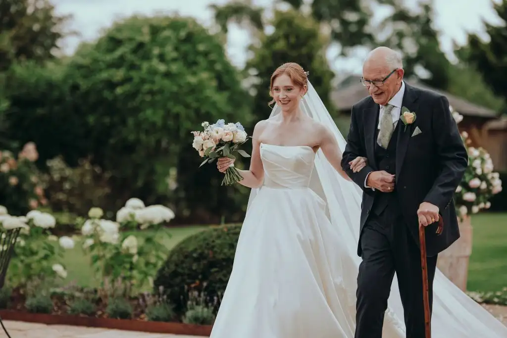 Bride walking with her father through the gardens before her Rowton Castle wedding ceremony