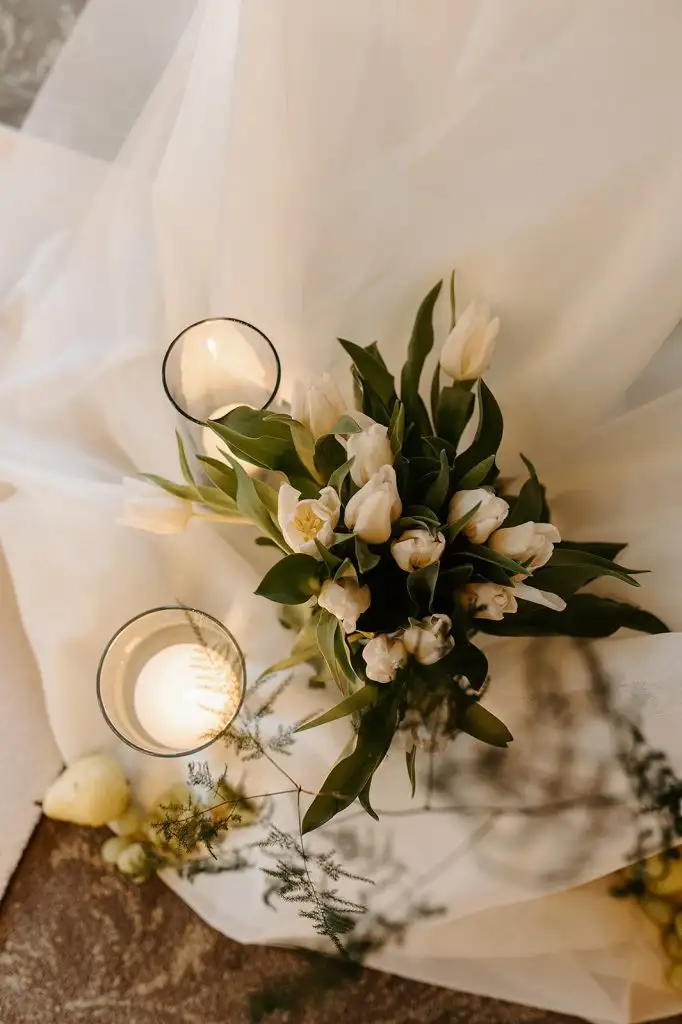Close-up of white tulip wedding flowers and candles decorating the ceremony aisle at Rowton Castle