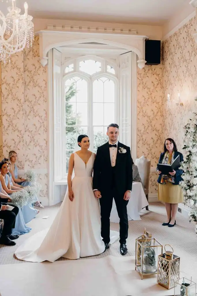 Bride and groom standing together during their wedding ceremony in the Rowton Castle ceremony room