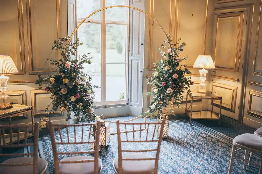 Small ceremony setup with floral arrangements and chairs inside Rowton Castle wedding venue